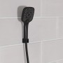 Schwarze, matte Schütte Handbrause Ravenna mit Antikalk-Noppen an weißer Wand.