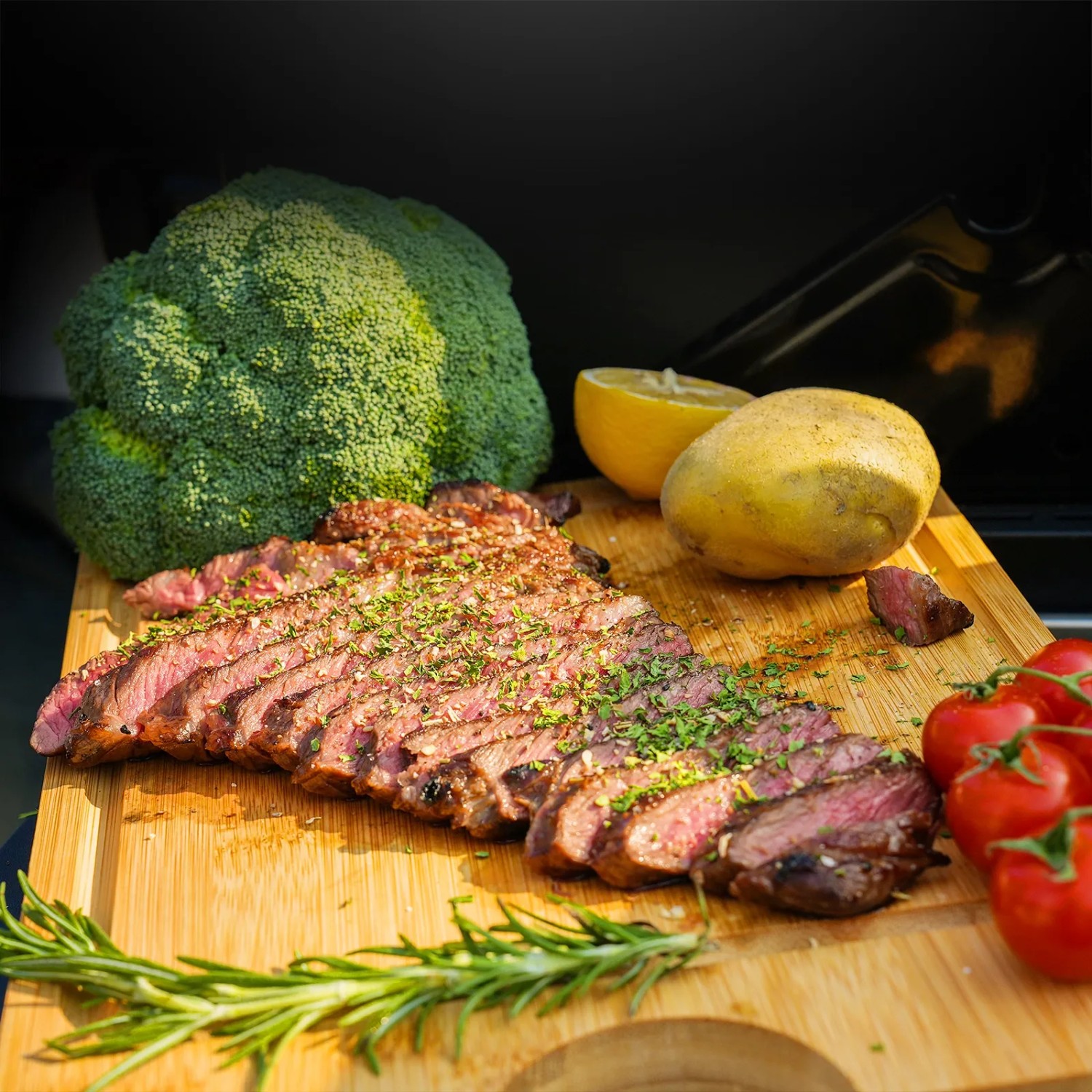 Angerichtetes Steak mit Gemüse auf Schneidebrett, zubereitet auf Taino Platinum Gasgrill.