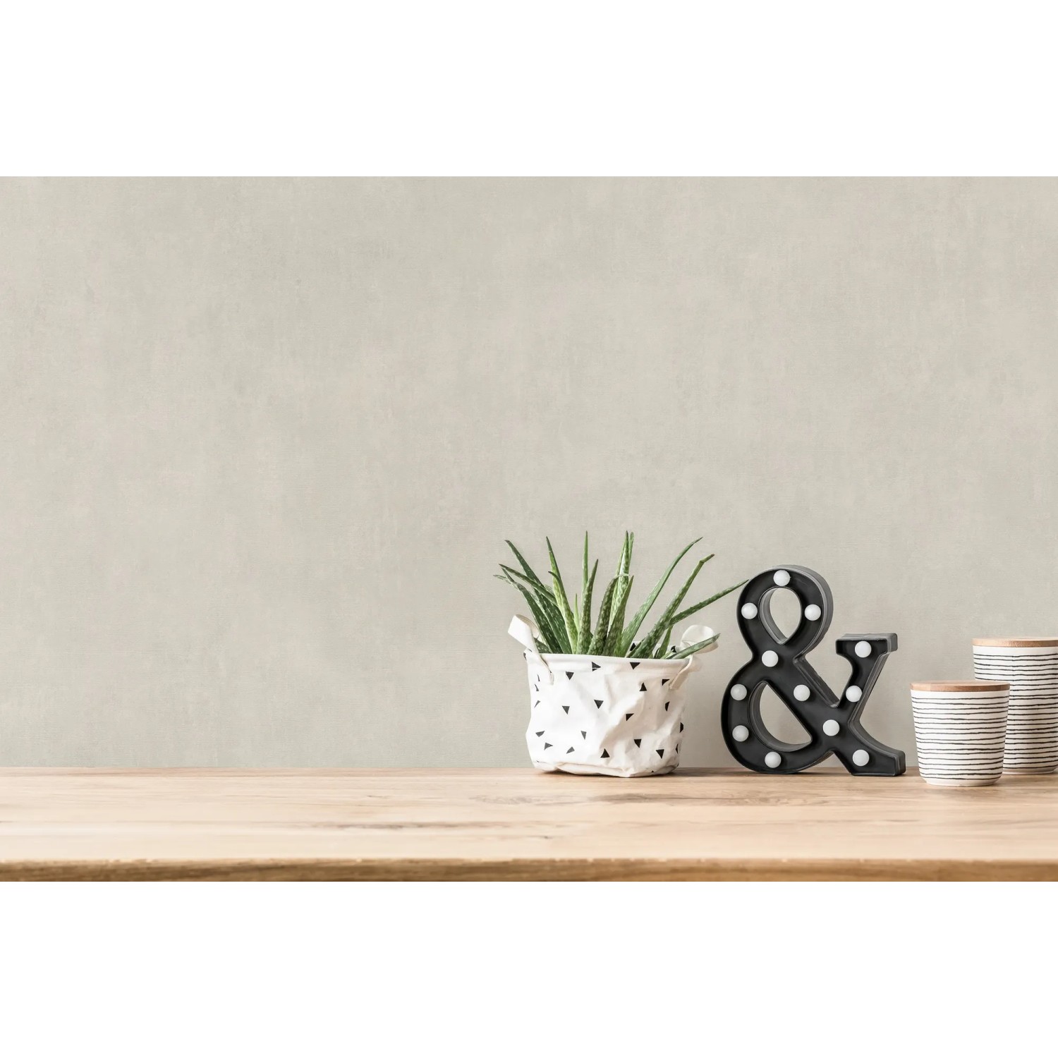 Beige-cremefarbene Vliestapete mit leichter Struktur an einer Wand, kombiniert mit Deko.