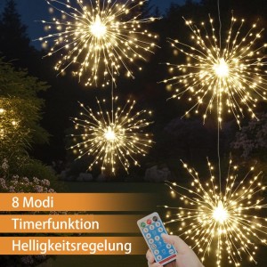 Vier warmweiße LED-Feuerwerk-Solarleuchten im Garten bei Nacht. Hand hält Fernbedienung für 8 Modi, Timer, Helligkeit.