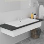 Modernes weißes Keramik Einbauwaschbecken mit Überlauf, integriert in eine schwarze Marmor-Waschtischplatte im Badezimmer.