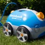 Steinbach Speedcleaner Poolrunner, ein Poolsauger in Blau/Grau mit Rädern und Kabel auf Rasen.