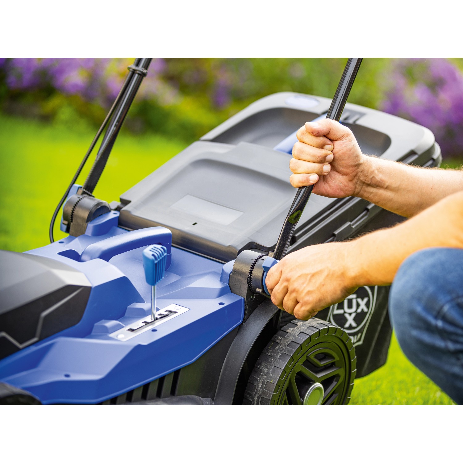 LUX-TOOLS Elektro-Rasenmäher E-RM-1800/43 in Aktion: Hand bedient Schnitthöhenverstellung.