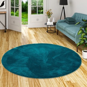Runder, petrolfarbener Hochflor Teppich "Silky" von Pergamon, 160x160cm, im Wohnraum.
