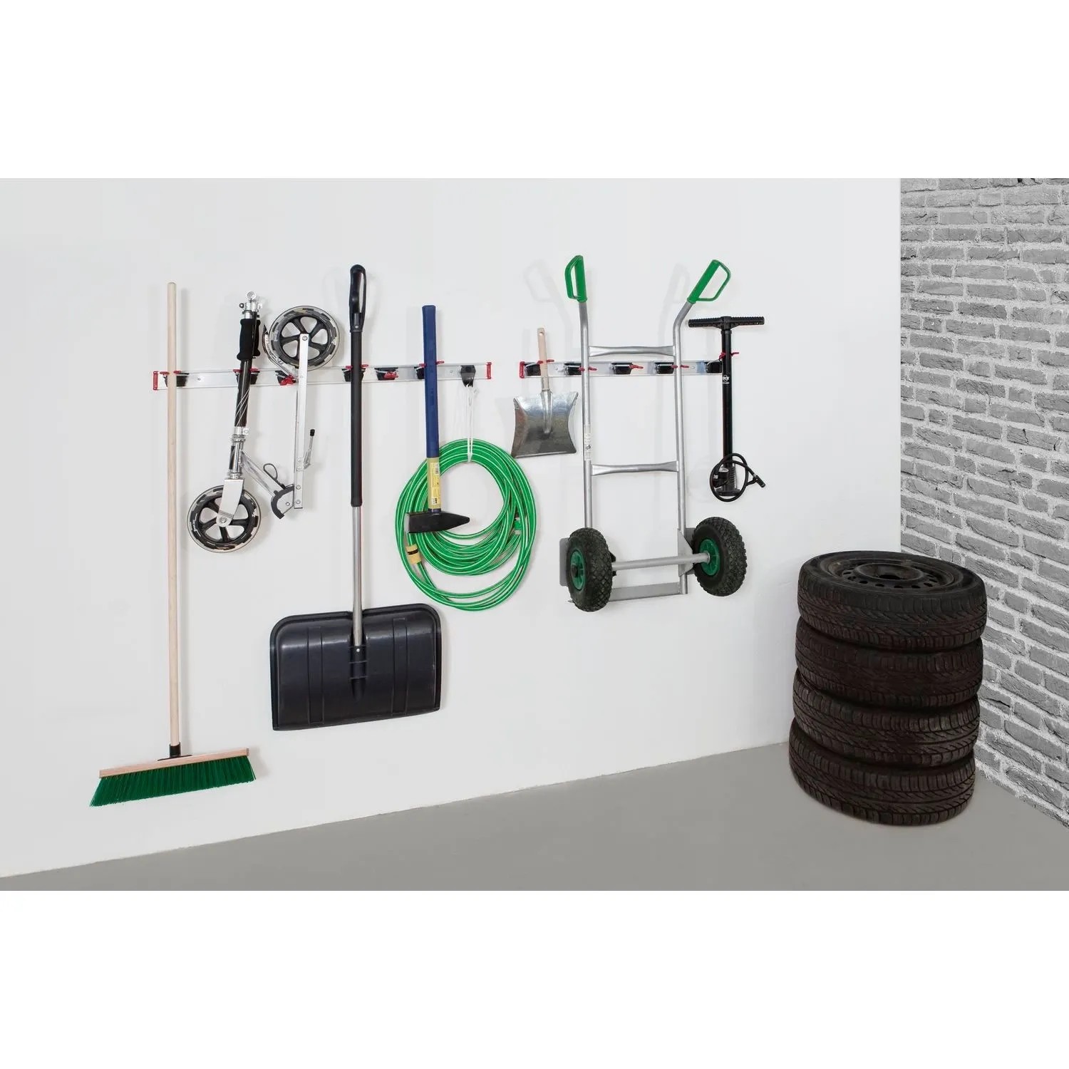 Bruns Gerätehalter Set schwarz-rot an weißer Wand mit Besen, Schaufel, Schlauch. Ordnungssystem für Garage.