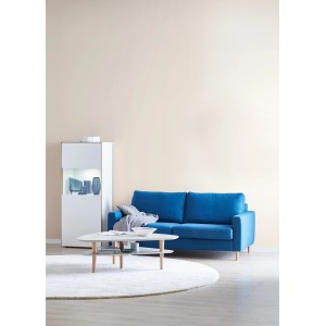 Wohnraum mit Schöner Wohnen Trendfarbe Pearl an der Wand, blaues Sofa, Tisch und Regal.
