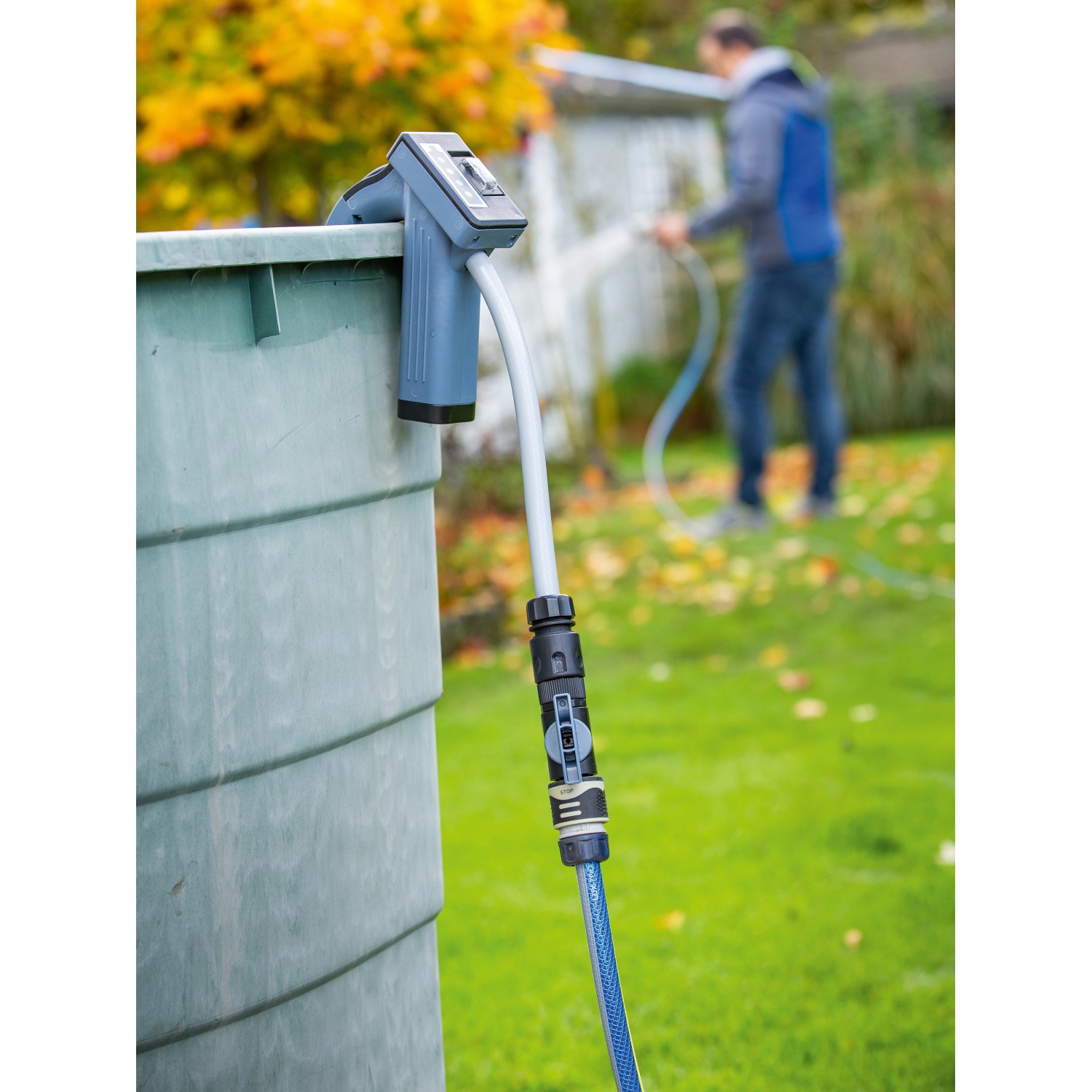 Akku-Regenfasspumpe (50 W) am Regenfass mit angeschlossenem Gartenschlauch im Einsatz.