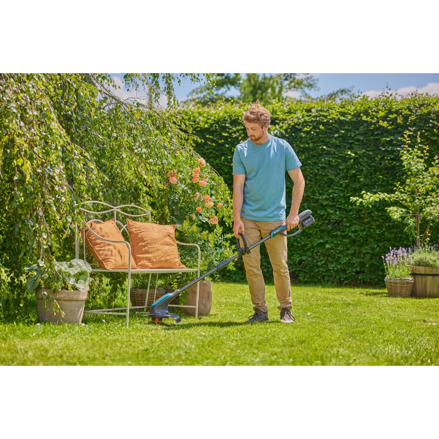 Mann trimmt Rasen mit Gardena Akku-Rasentrimmer PowerTrim 30/18V Solo im Garten.