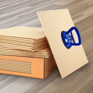 Blauer Saugheber aus ABS-Kunststoff und Gummi auf heller Fliese. Handwerkzeug zum Heben von Platten und Scheiben.