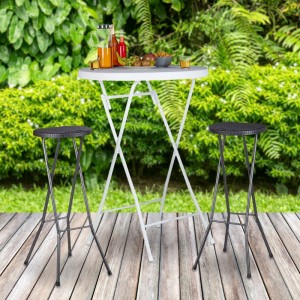 Zwei schwarze klappbare Barhocker aus Polyrattan und Stahl auf Holzterrasse mit Stehtisch im Garten.