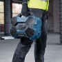 Bosch Professional Bluetooth-Lautsprecher GPB 18V-6C, getragen von einer Person auf einer Baustelle.