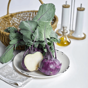 Blauer Kohlrabi (Brassica oleracea) auf Teller, angeschnitten. Frisches Gemüse für Salat und Eintopf.