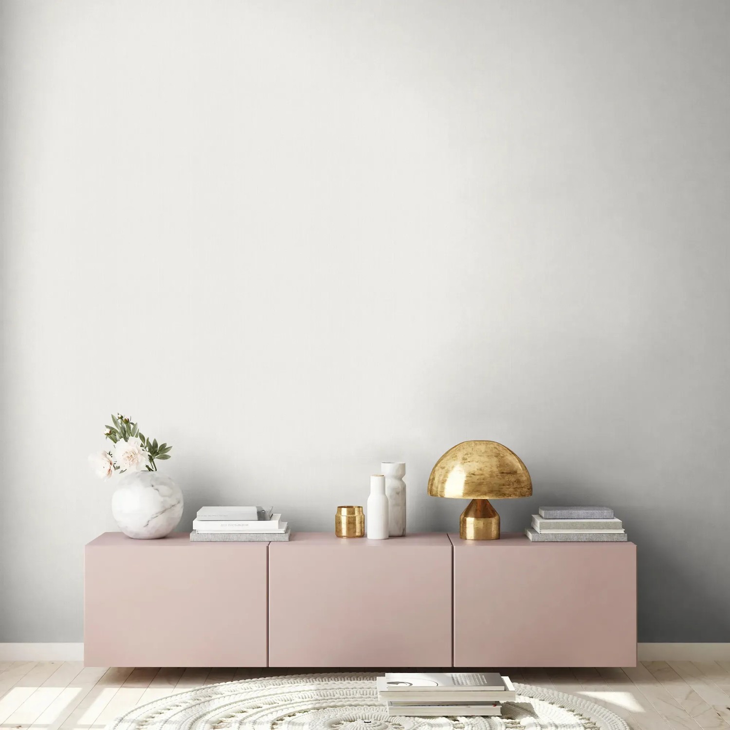 Wohnraum mit weißer Vliestapete Uni Metallic, rosa Sideboard und Deko.