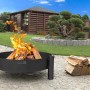 Schwarze CookKing Feuerschale Haiti (Ø 68cm) mit Feuerholz im Garten.