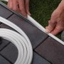 Paulmann LED-Stripe Plug & Shine Smooth, weiße Außenbeleuchtung, wird an einem Weg installiert.