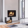 Schwarzer Kaminholzständer aus Stahl mit Tragetasche, gefüllt mit Brennholz, vor einem modernen Kamin im Wohnzimmer.