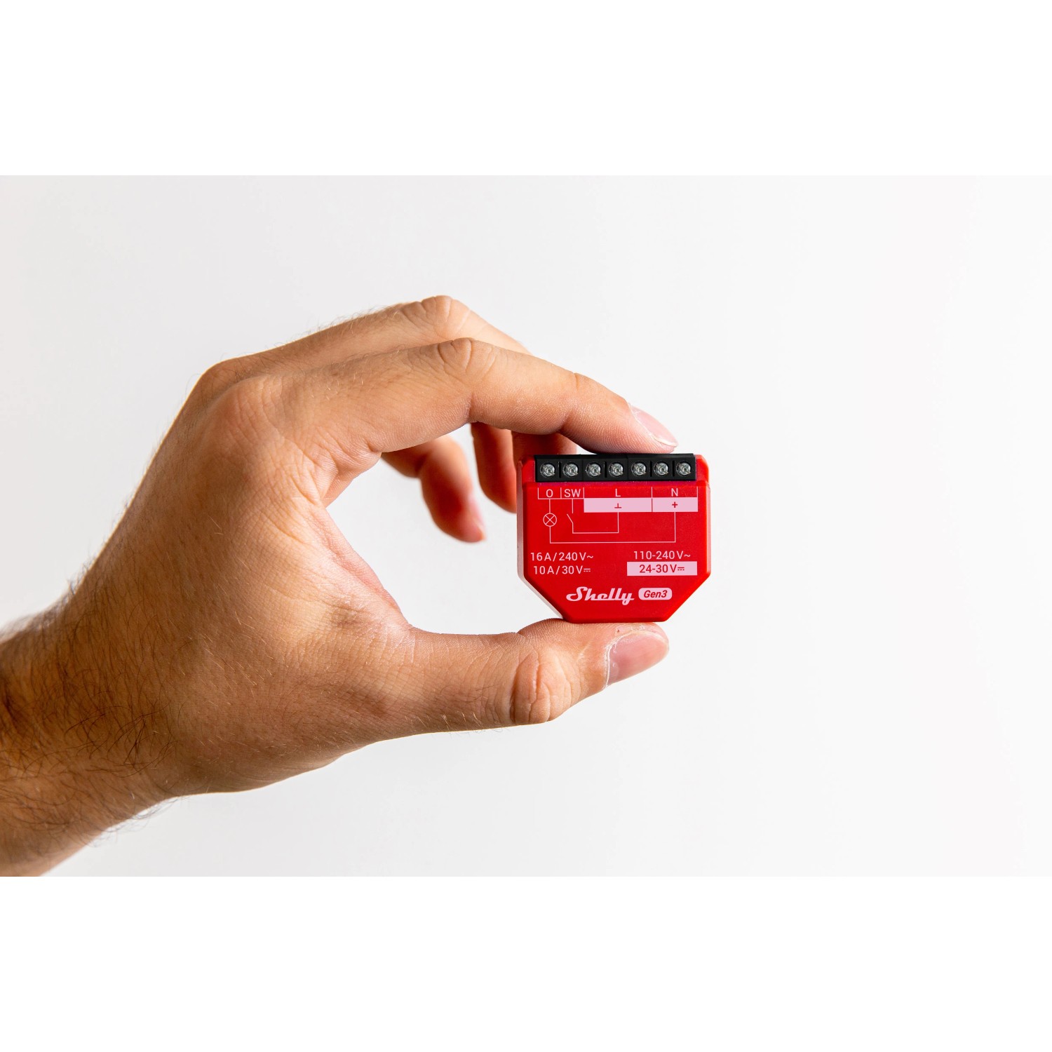 Rotes Shelly Relaismodul Unterputz 0/1-10V PM Gen3 in Hand, Detailaufnahme.