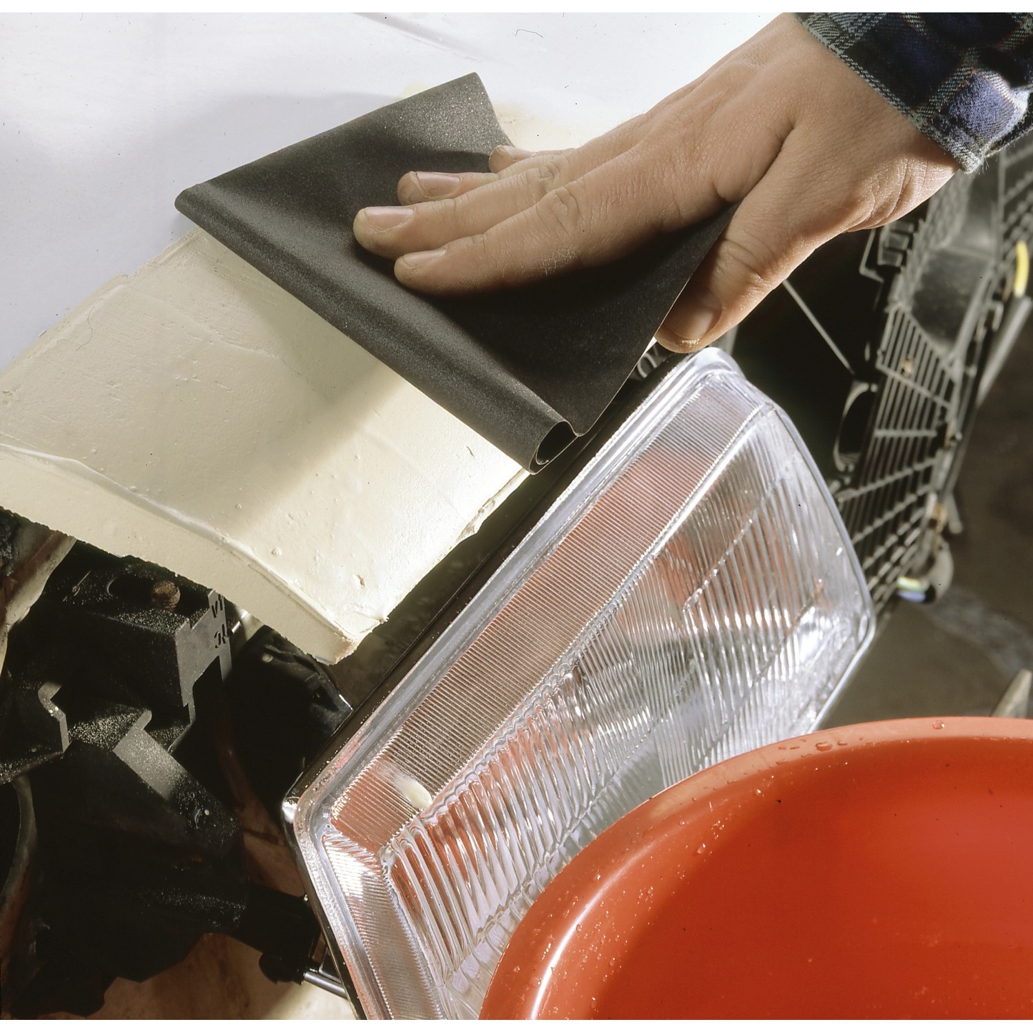 Hand schleift Spachtel mit LUX Nass-Schleifpapier K80. Schleifmittel für Oberflächenbearbeitung.