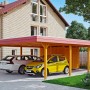 Skan Holz Doppelcarport Wendland Eiche hell mit Anbau und zwei geparkten Autos.