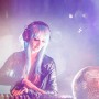 Frau mit blauen Haaren, Kopfhörern und Discokugel im Hintergrund. Party-Stimmung mit Lampe & Leuchte.
