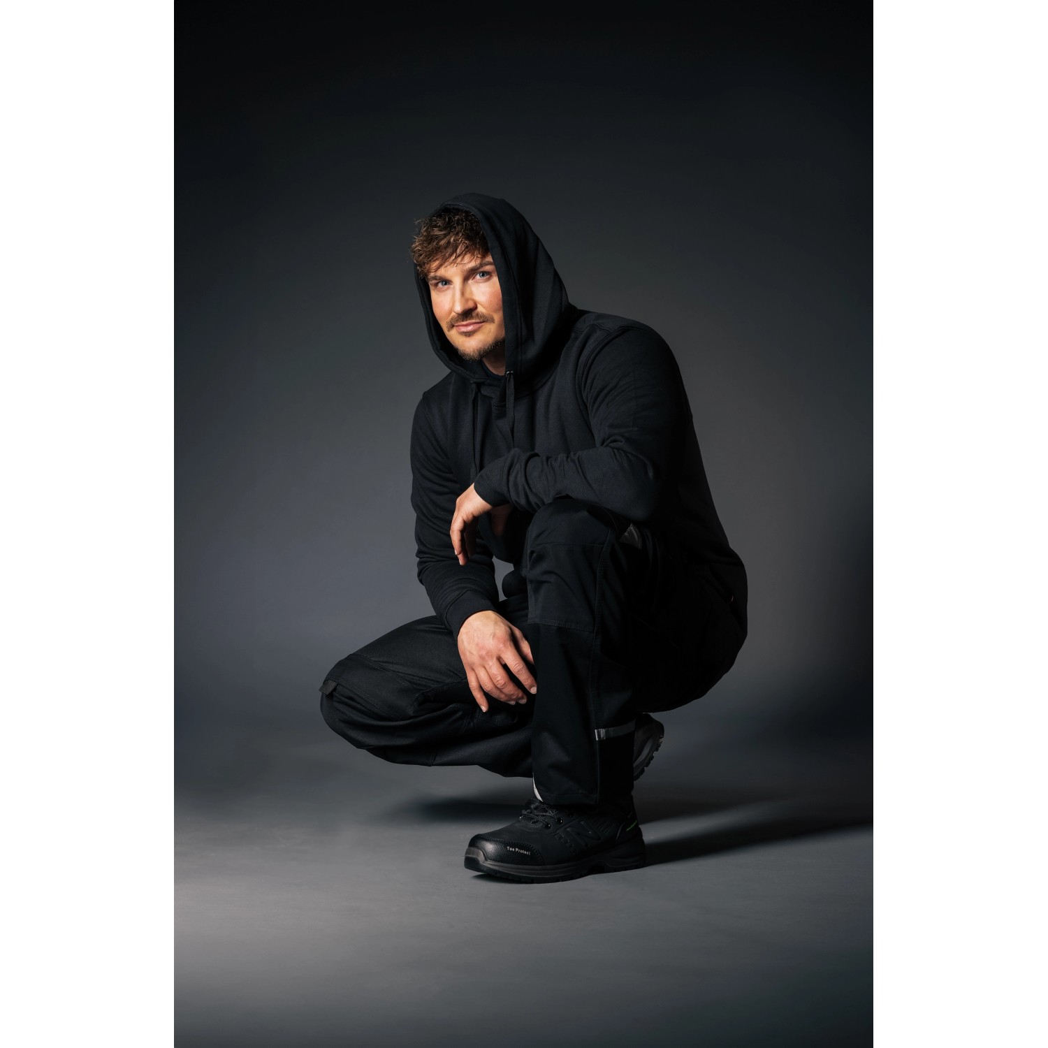 Schwarze New Balance Calibre S3L Sicherheitsstiefel Gr. 40 für Herren, kniend dargestellt.