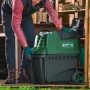 Bosch Gartenhäcksler AXT 25 TC in Grün/Schwarz mit Bediener vor Holzschuppen.