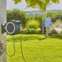 Gardena Akku-Wand-Schlauchbox PowerRoll XL mit Mann beim Bewässern des Gartens.