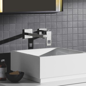 Moderne Grohe Eurocube 2-Loch Waschtischarmatur in Chrom, wandmontiert über einem weißen Aufsatzwaschbecken.