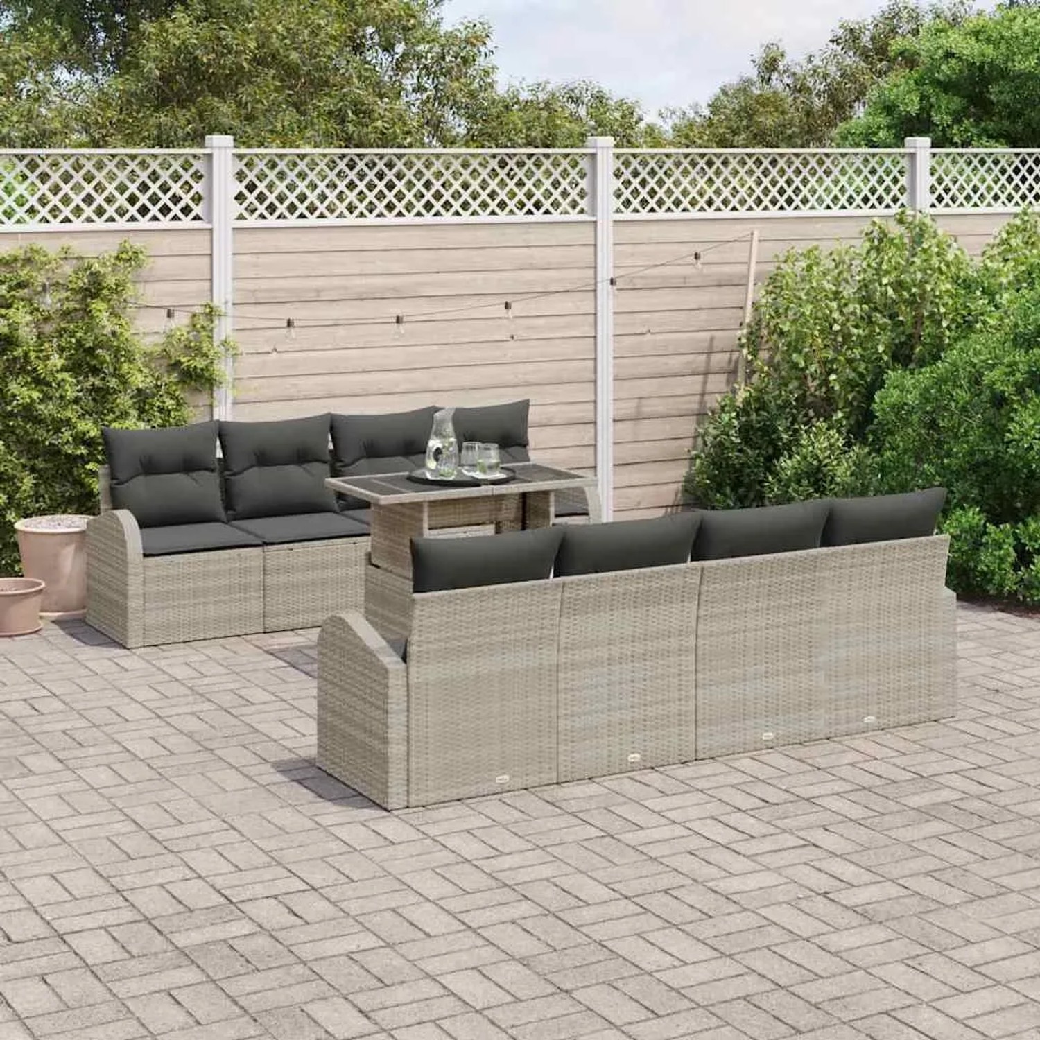 Hellgraues 7-teiliges Garten-Sofa-Set aus Poly Rattan mit Tisch und Kissen.