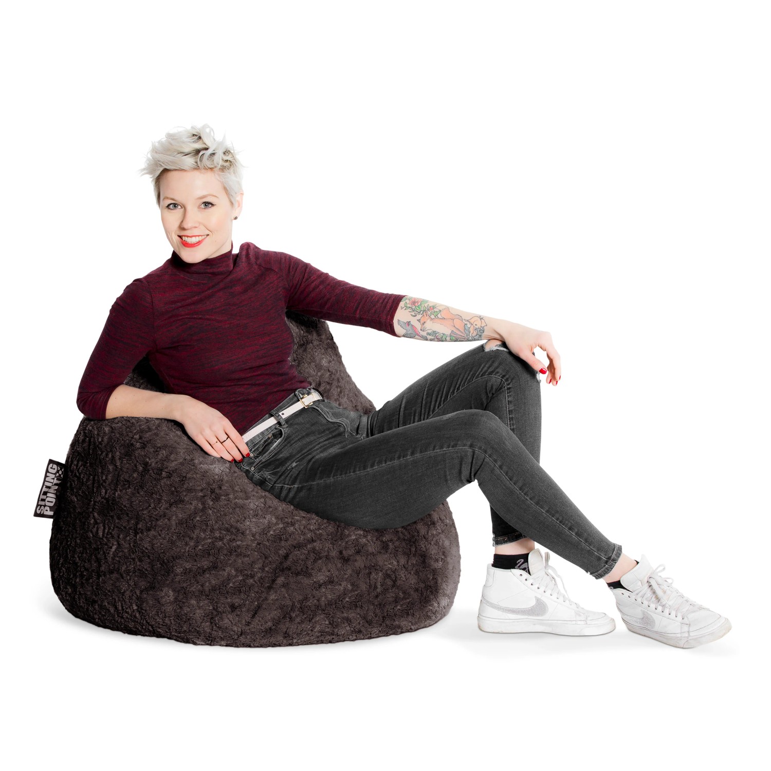 Frau sitzt entspannt im anthrazitfarbenen Sitting Point Sitzsack Fluffy 220 l.