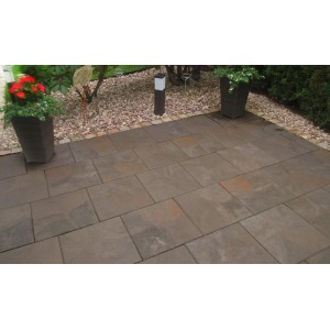 Verlegte Diephaus Finessa Terrassenplatten Marrone 40x40 cm auf einer Terrasse mit Bepflanzung.