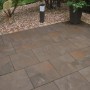Verlegte Diephaus Finessa Terrassenplatten Marrone 40x40 cm auf einer Terrasse mit Bepflanzung.