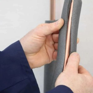 Schwarze, selbstklebende Aeroflex Rohrisolierung (15x10 mm) aus Schaumstoff auf Kautschukbasis wird an einem Rohr befestigt.