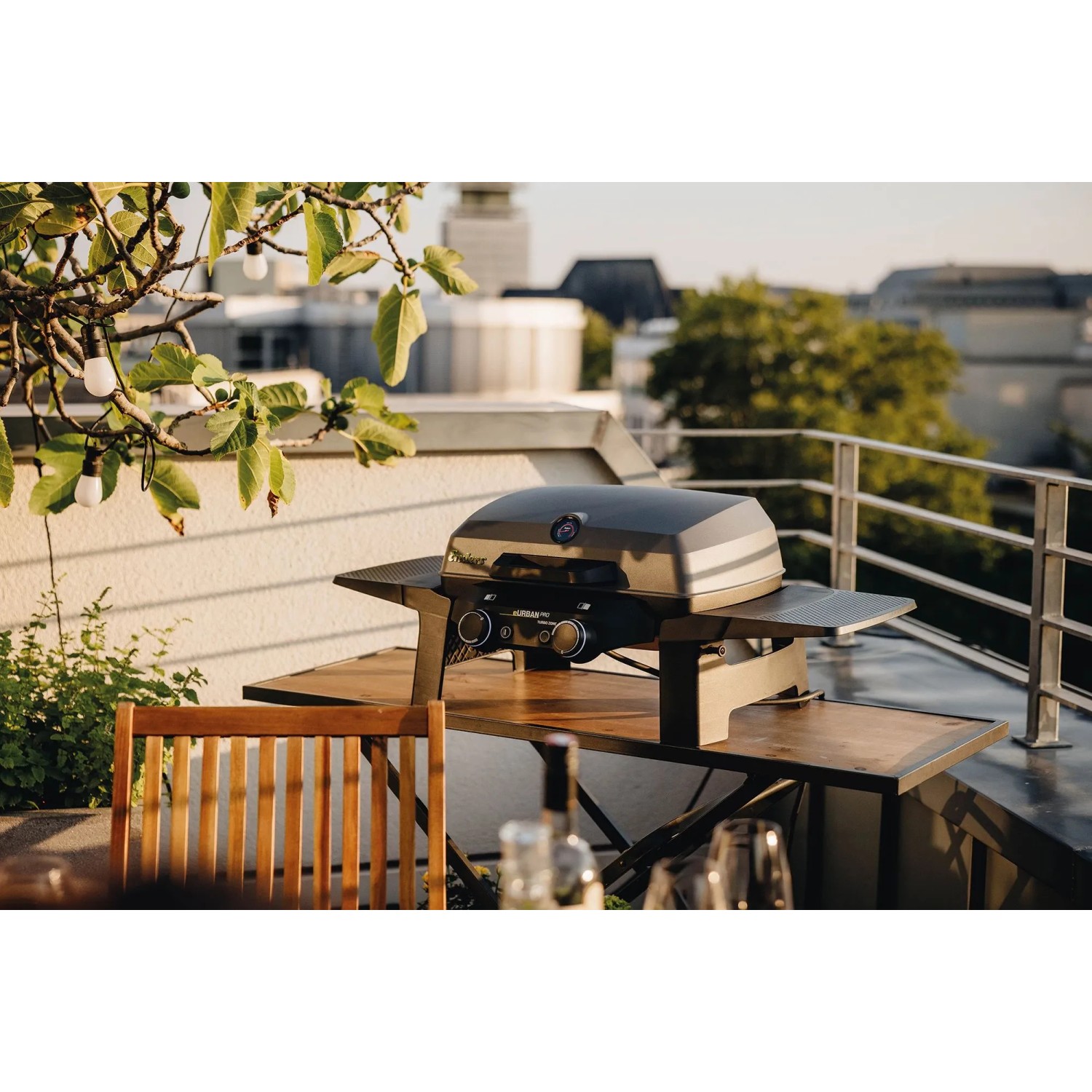 Enders Elektrogrill eUrban Pro 2 Turbo Mobil auf Tisch mit Seitenablagen auf Balkon.