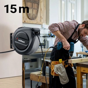 Wiltec Kabeltrommel 15m mit automatischem Aufroller an Wand, Mann bohrt in Werkstatt. Ideal für Kabel & Leitungen.