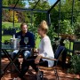 Juliana Gewächshaus Orangerie 15: Paar entspannt mit Wein im schwarz-anthrazitfarbenen Gewächshaus.