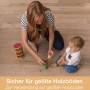 Frau und Baby spielen auf geöltem Holzboden mit Holzspielzeug. Bona Reiniger geeignet.