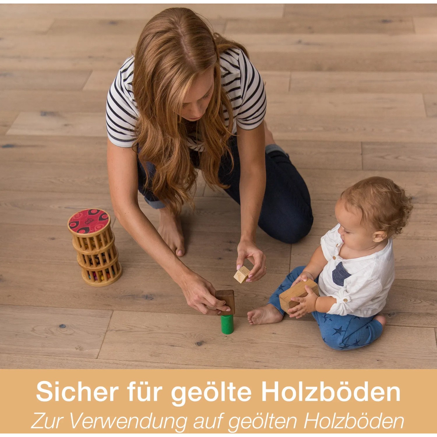 Frau und Baby spielen auf geöltem Holzboden mit Holzspielzeug. Bona Reiniger geeignet.