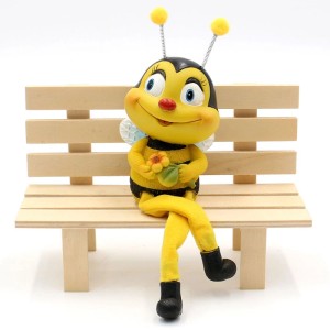 Dekorative Bienen-Figur als Kantenhocker, sitzend auf einer Bank. Niedliche Bienendeko für Zuhause.