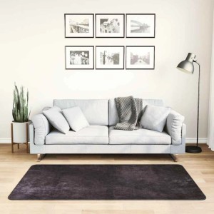 Anthrazitfarbener, waschbarer Teppich 80x150 cm im Wohnzimmer vor grauem Sofa. Rutschfest, weicher Samt.
