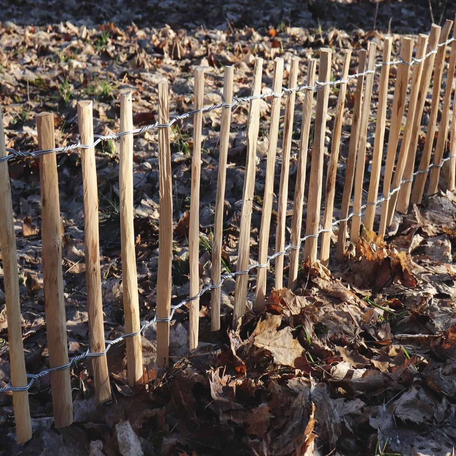 Aquagart Staketenzaun aus Haselnussholz, 60cm hoch, mit verzinktem Draht im Garten.