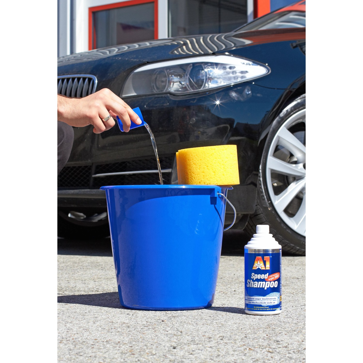Dr. Wack A1 Speed Shampoo 500ml mit Eimer, Schwamm und Auto im Hintergrund.