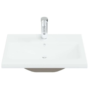 Weißes Keramik Einbauwaschbecken mit glänzendem Wasserhahn. Modernes Design für Bad und Gäste-WC.