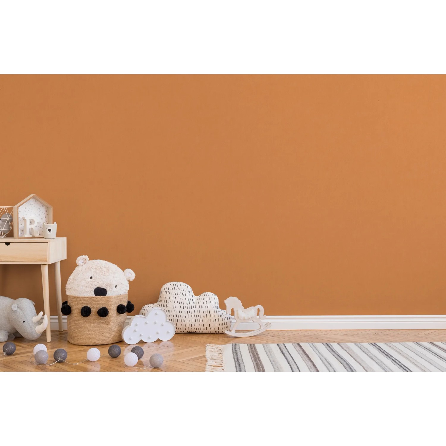 Kinderzimmer mit orangefarbener Vliestapete Uni und Spielzeugdekoration.