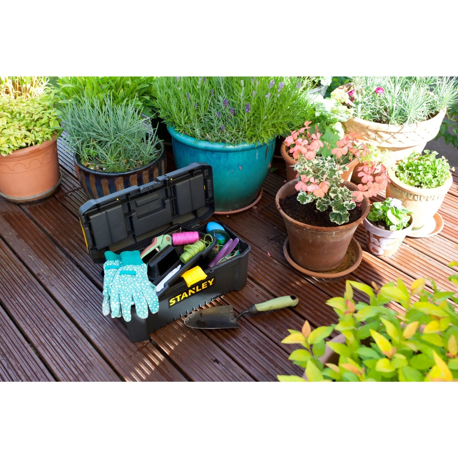 Offene Stanley Kunststoffbox 16 mit Gartenzubehör vor Pflanzen. Aufbewahrungsbox mit Organizern.