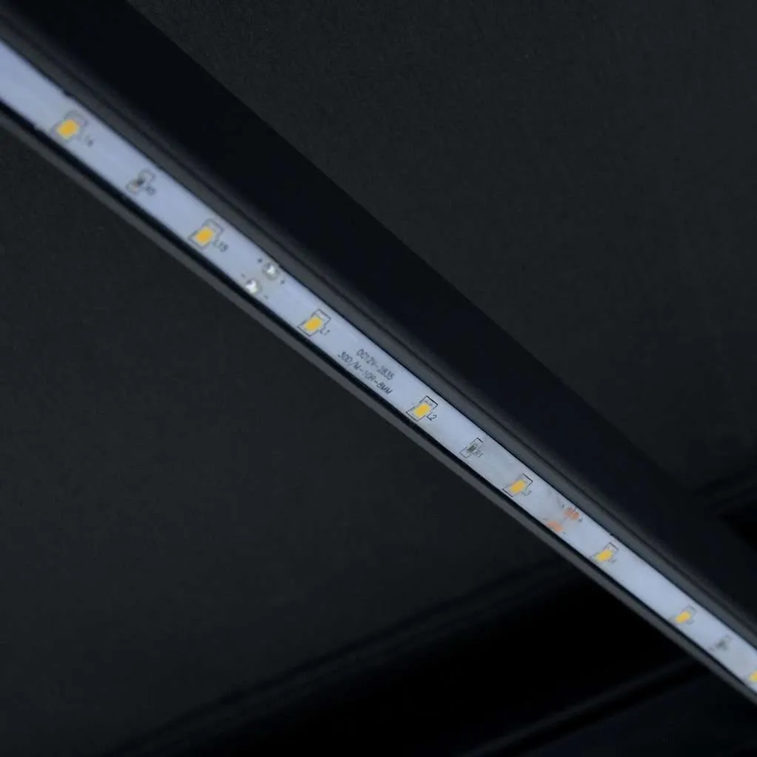 Detailansicht der LED-Beleuchtung an einer vidaXL Markise. Helle LEDs sind in den dunklen Rahmen integriert.