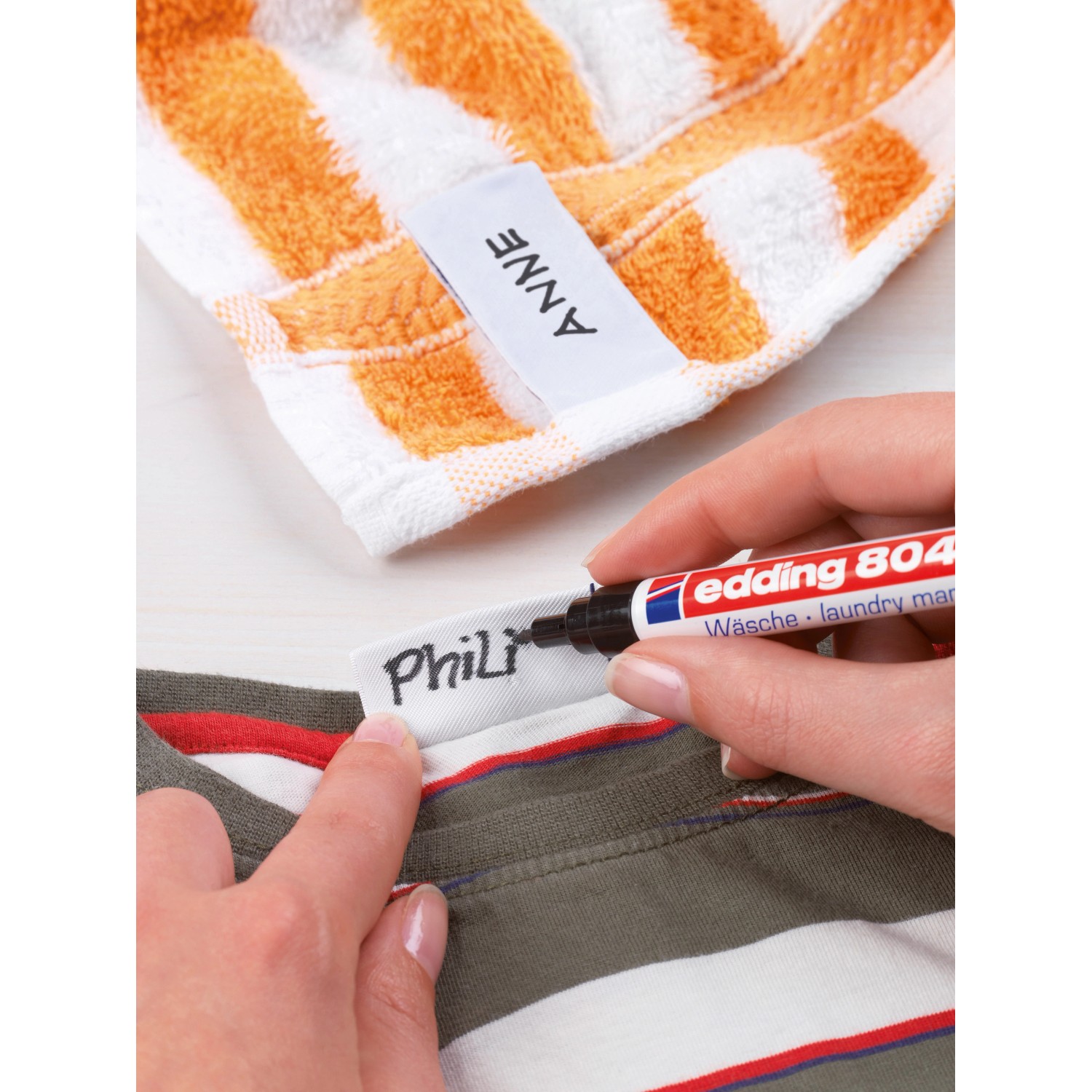 Edding 8040 Wäschemarker in Schwarz beim Beschriften eines Textiletiketts.