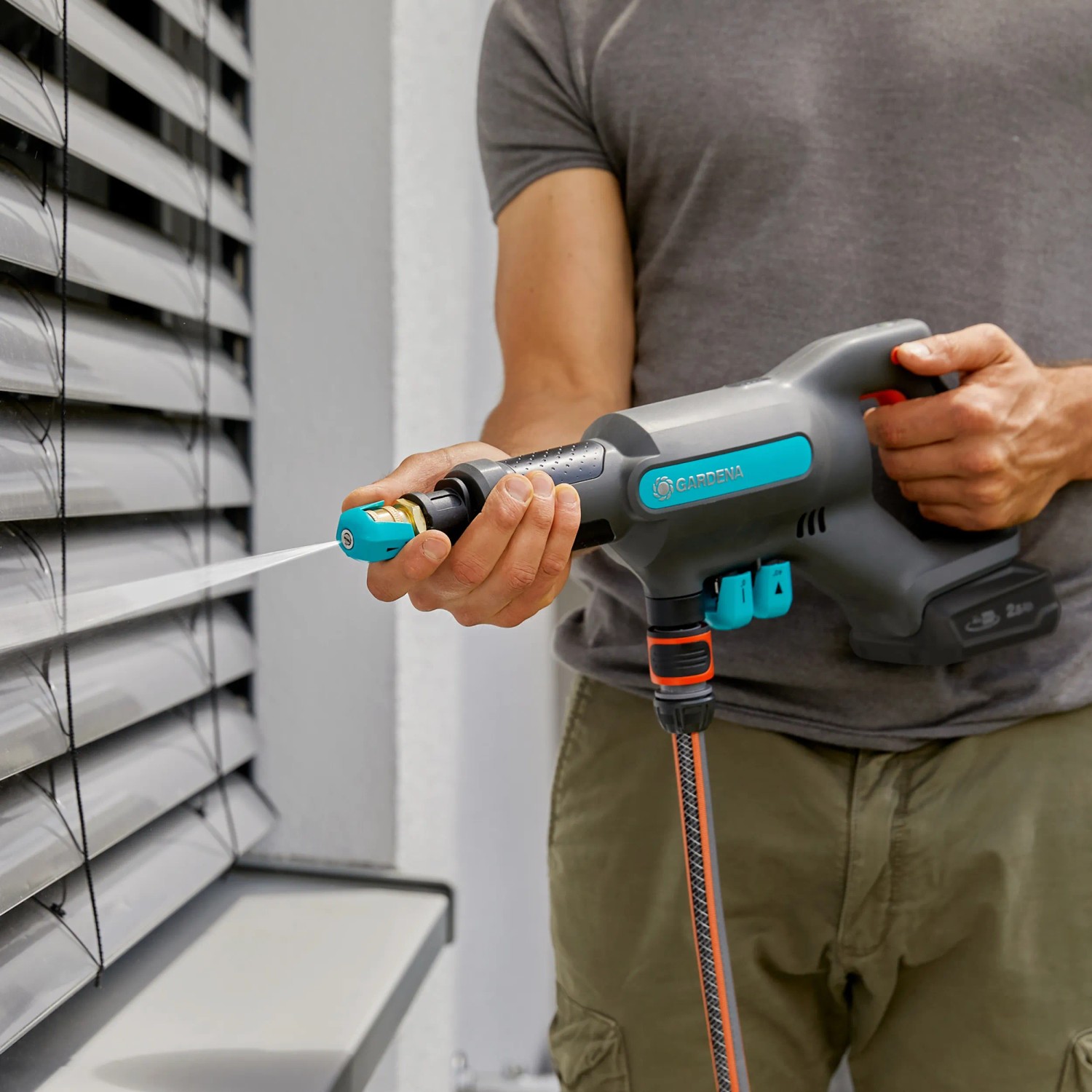 Gardena AquaClean 24/18V Akku-Mitteldruckreiniger in Aktion mit Wasserstrahl.