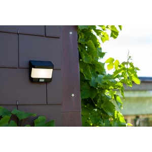 Lutec LED Solar Wandleuchte Try, mattschwarz, mit Bewegungsmelder an Hauswand.