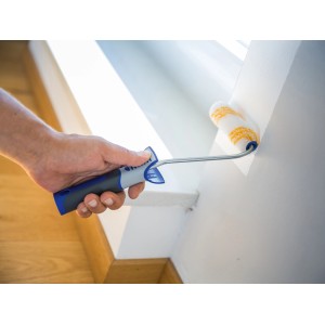 Hand streicht mit LUX Dispersionsroller (12 cm) eine weiße Wand. Farbwalze für glatte Flächen.